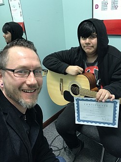 A student getting an achievement award for memorizing the 1st Position Chords